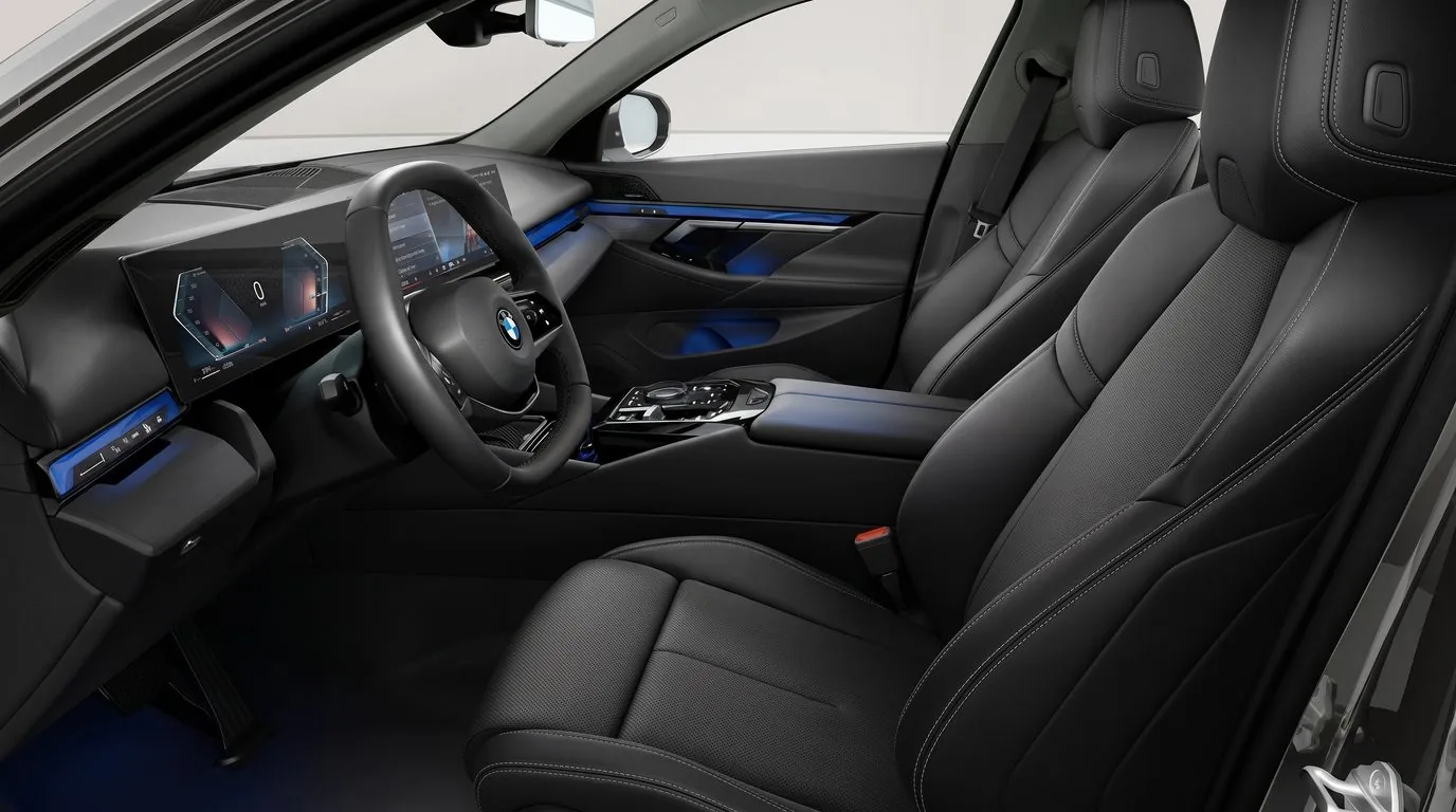 Vordersitze des BMW 540d xDrive Touring in schwarzem Veganza-Leder mit Blick auf Cockpit und Mittelkonsole, Innenraum