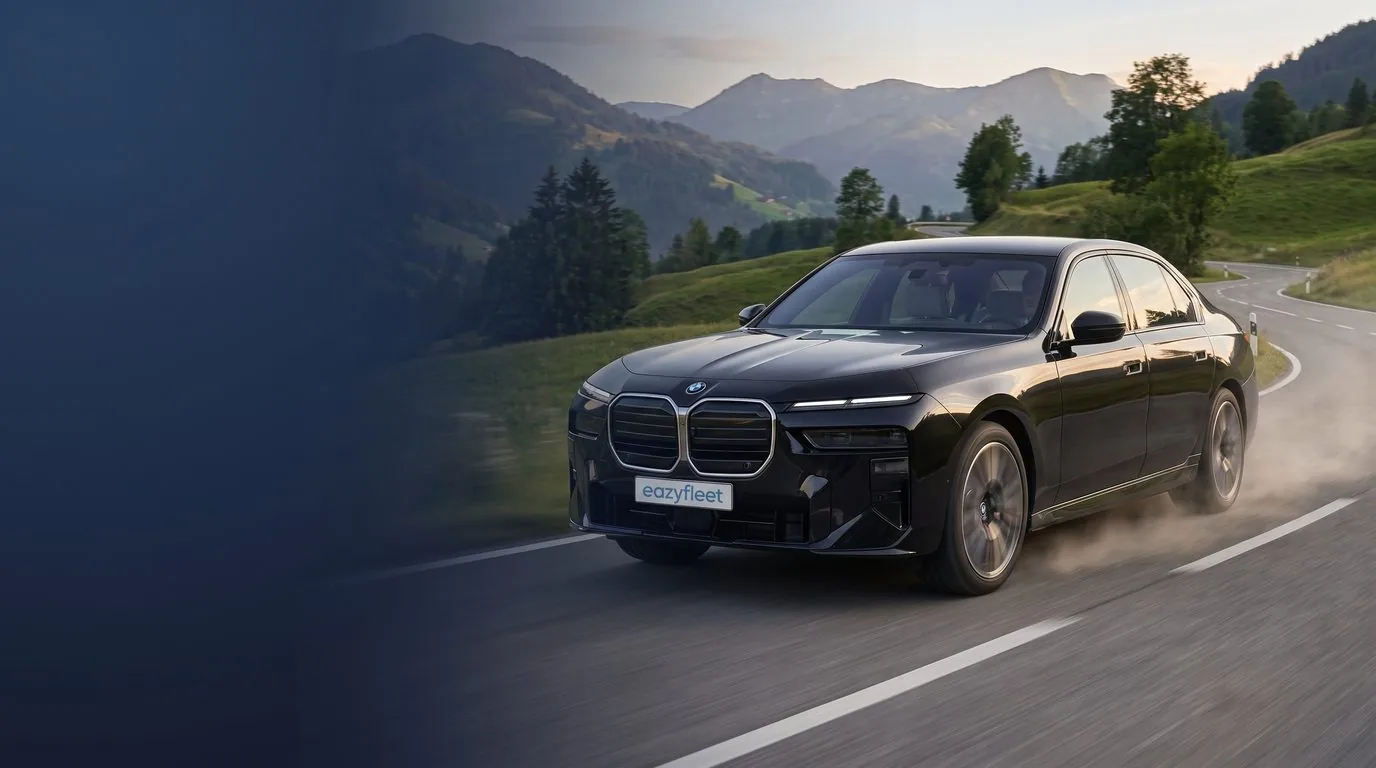 BMW 740d xDrive in Saphirschwarz metallic auf Schotterweg vor grünen Hügeln, Firmenwagen-Flotte im Eazyfleet Plus Abo